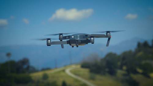 aircraft shallow focus photography of quadcopter on mid air airplane